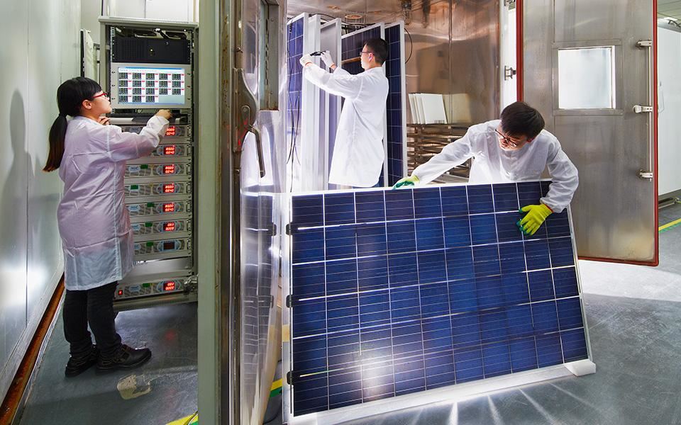 Factory workers handling solar module in research lab