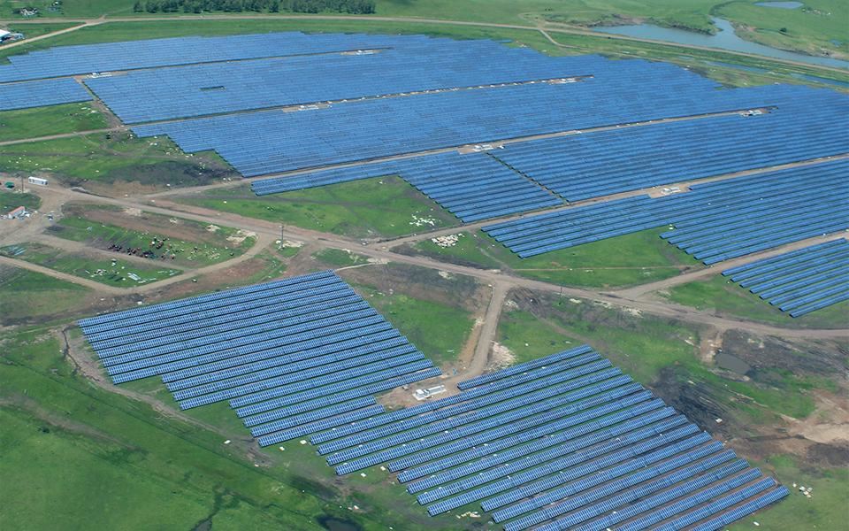 Aerial view of large-scale utility solar installation on flat landscape