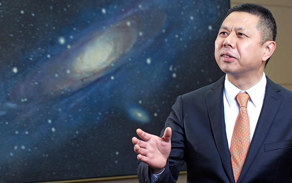 Jifan Gao speaking with backdrop of Milky Way galaxy